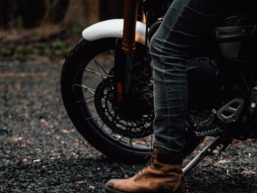 Hotel Böhlerstern: biker hotel in Styria Leg with brown boot next to black motorcycle on gravel ground