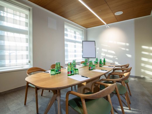 Böhlerstern: das Hotel in Kapfenberg für Seminare und Veranstaltungen Heller Konferenzraum mit Holztisch, Stühlen, Wasserflaschen, Zetteln und Flipchart