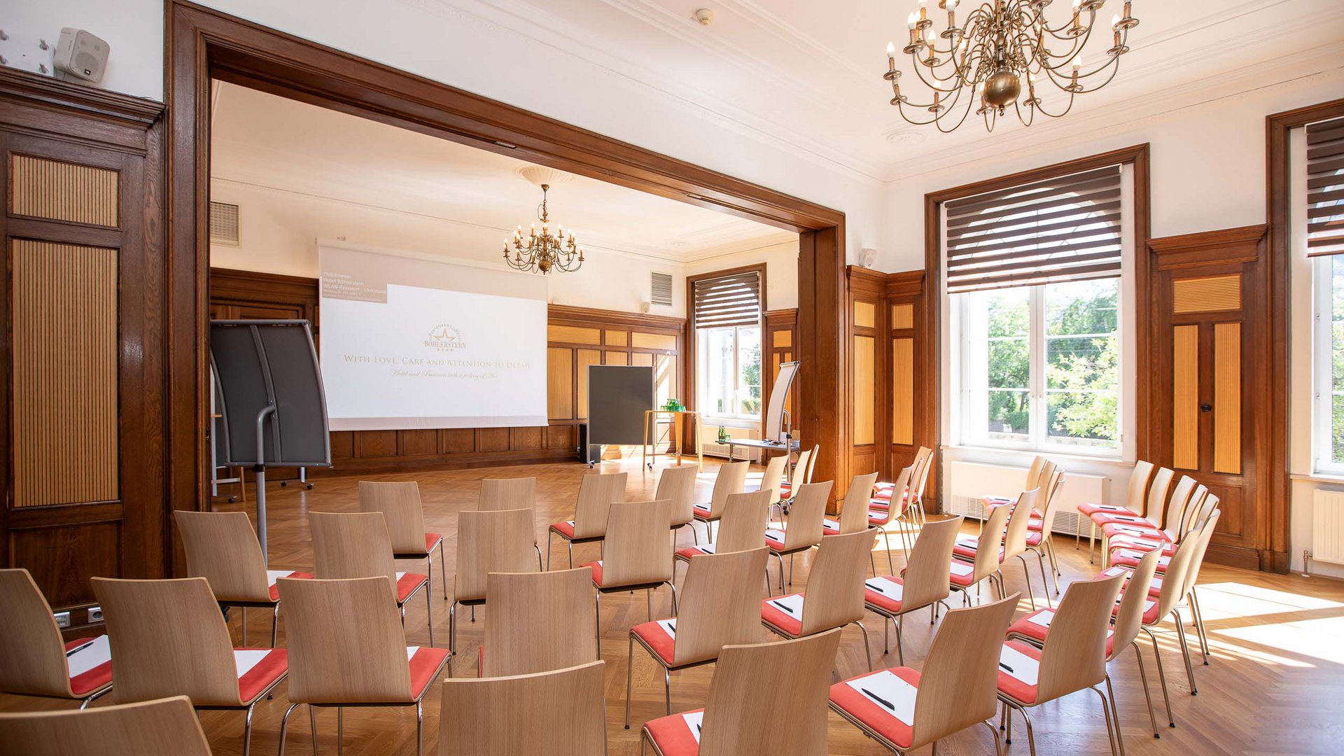 Hotel Böhlerstern: theatre hall, seminar rooms, and more Bright seminar room setup with chairs, blackboard, projector screen, and chandeliers